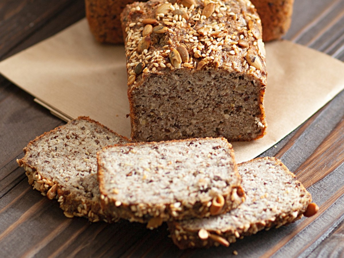 Angeschnittenes K&ouml;rnerbrot auf einem Holztisch.