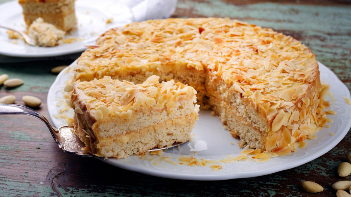 Mandeltorte mit Eierlikörcreme in der Mitte auf weißem Teller.