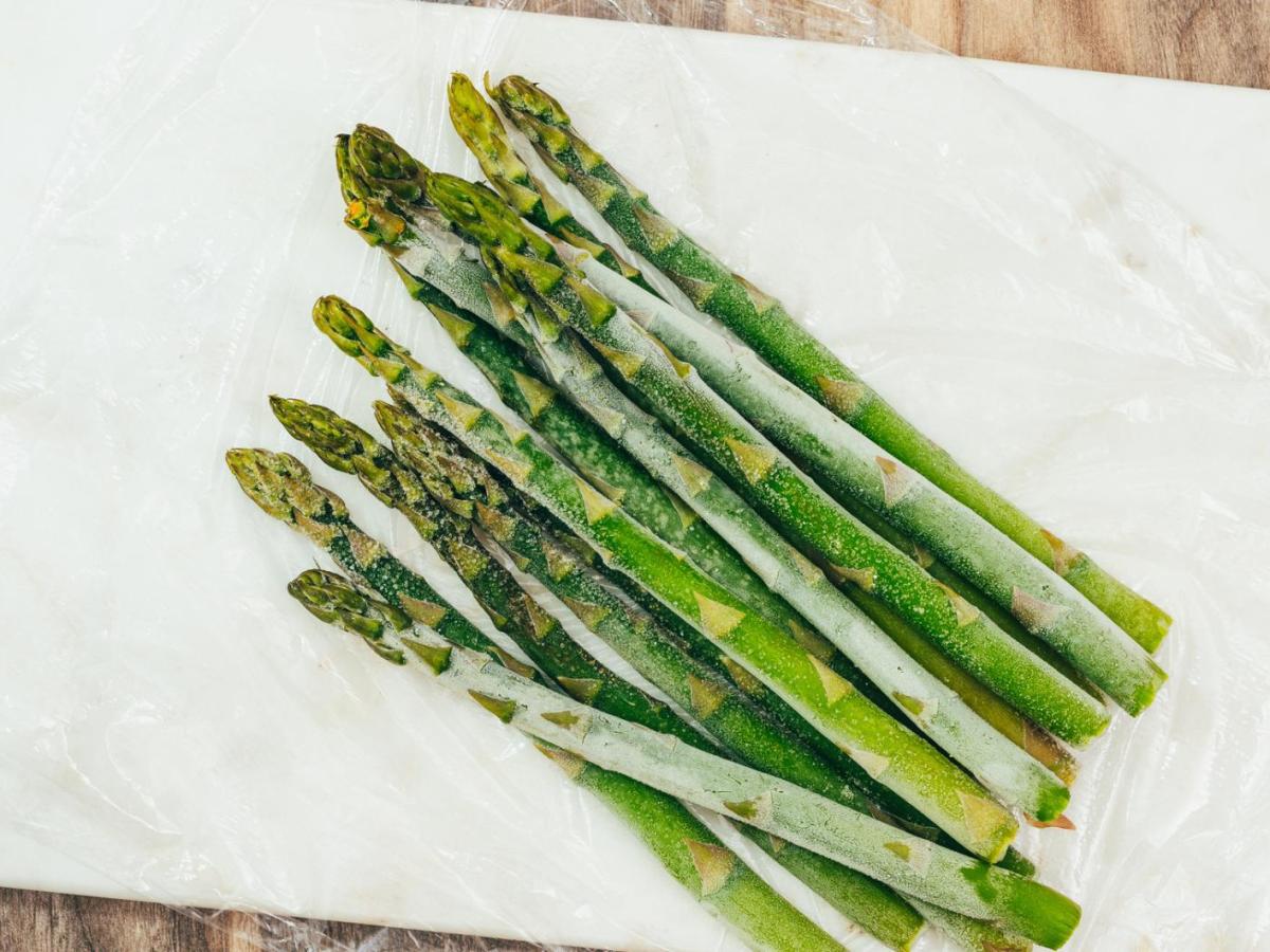 Gefrorene Spargelstangen liegen auf einem Küchenkrepp.