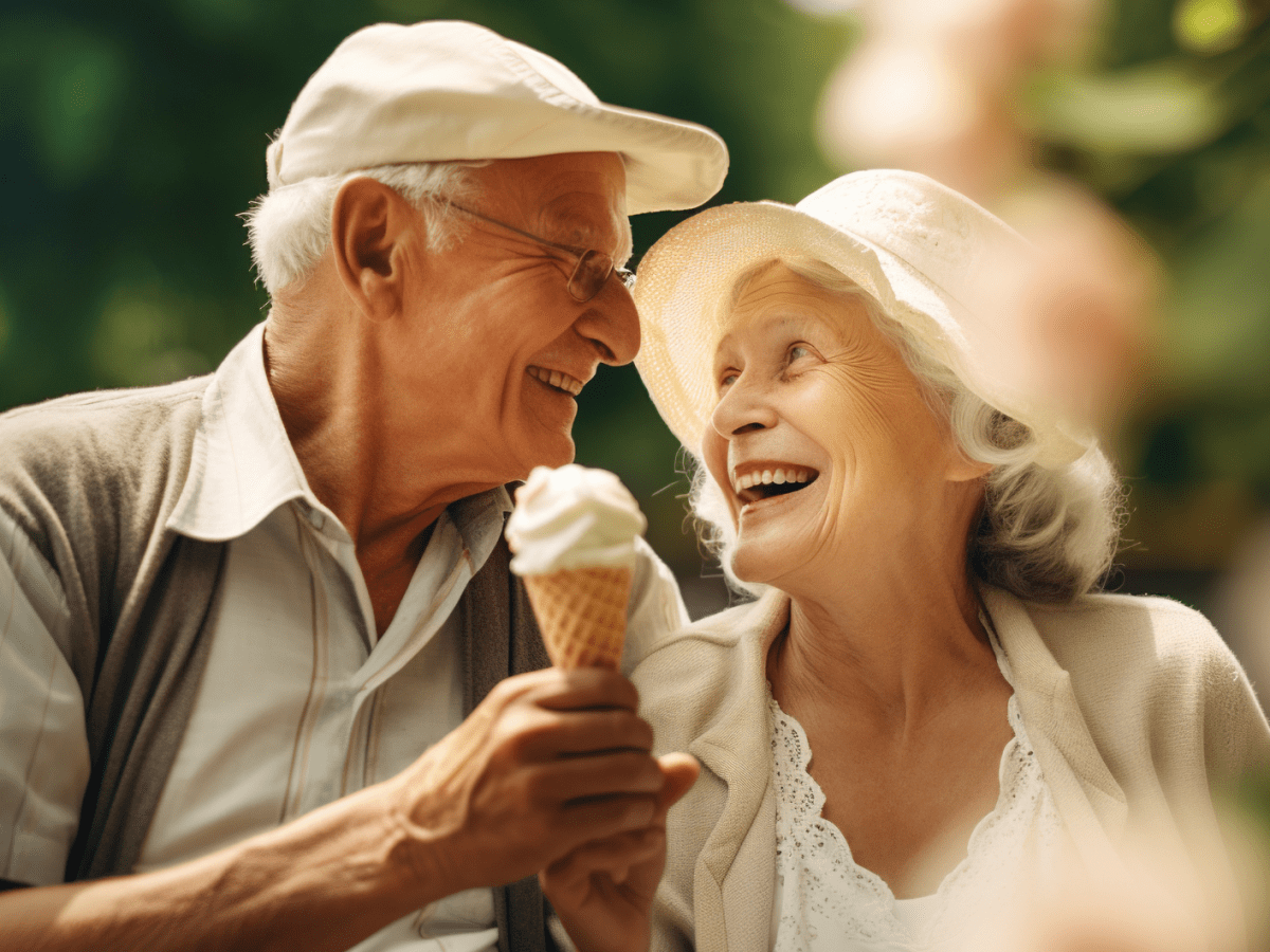 &Auml;lteres P&auml;rchen mit einem Eis in der Hand, die sich anl&auml;cheln.