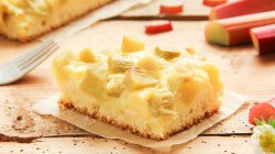 Blechkuchen mit Pudding und Rhabarber auf einem St&uuml;ck Backpapier.