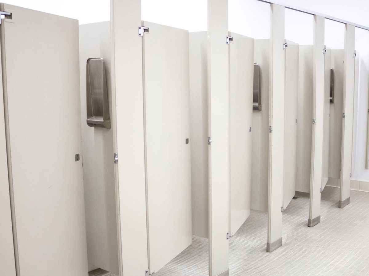 &Ouml;ffentliche Toilette mit mehreren Kabinen, die alle ein St&uuml;ck ge&ouml;ffnet sind.