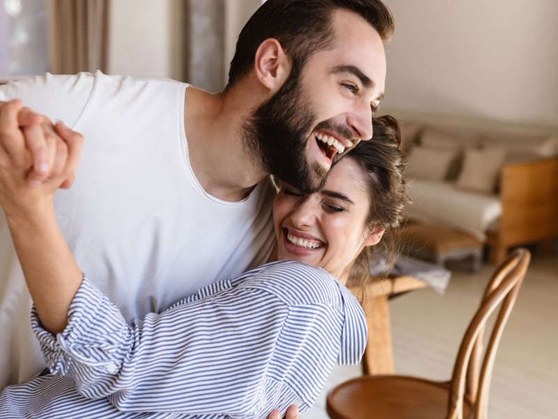 Mann und Frau tanzen im Wohnzimmer