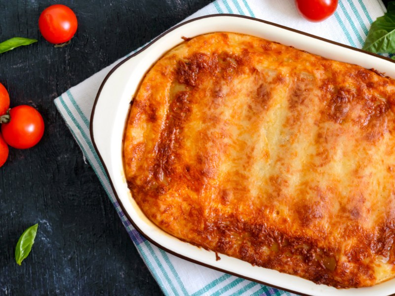 Cannelloni mit Käse überbacken in weißer Auflaufform.