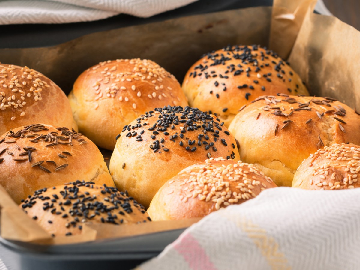 Br&ouml;tchen mit K&ouml;rner obendrauf auf einem Backblech.