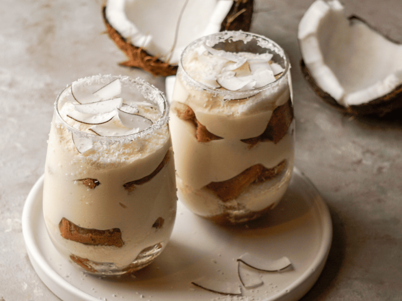 Zwei Gläser mit Kokos-Tiramisu auf einem Tisch.