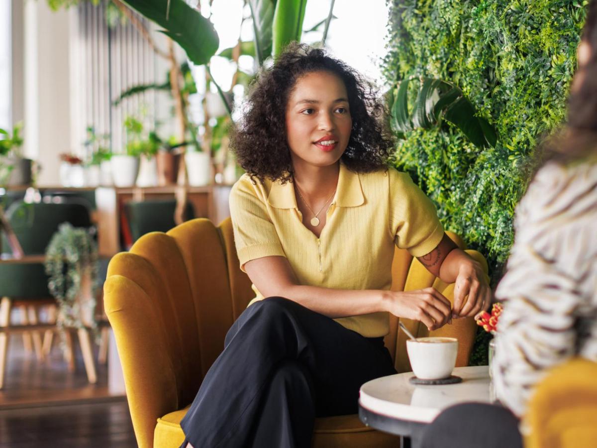 Frau sitzt in der Pause mit einer Kollegin im B&uuml;ro und hat die Beine &uuml;betschlagen.