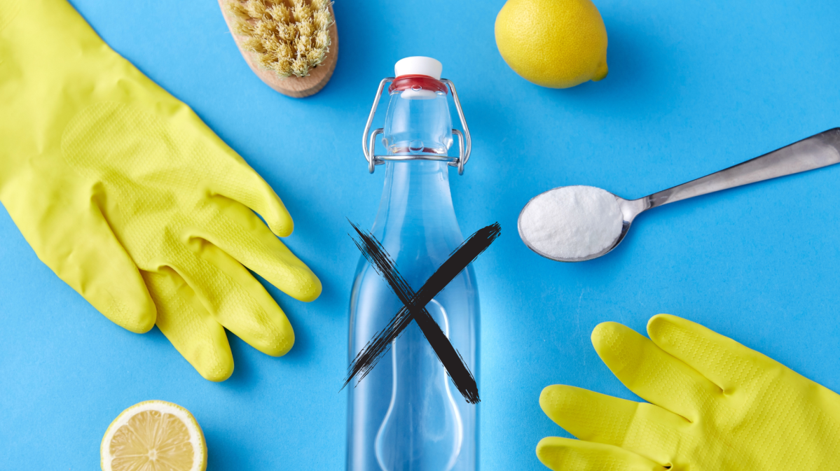 Handschuhe, Zitrone, eine Flasche Essig und Natron auf einem Löffel liegen vor einem blauen Hintergrund