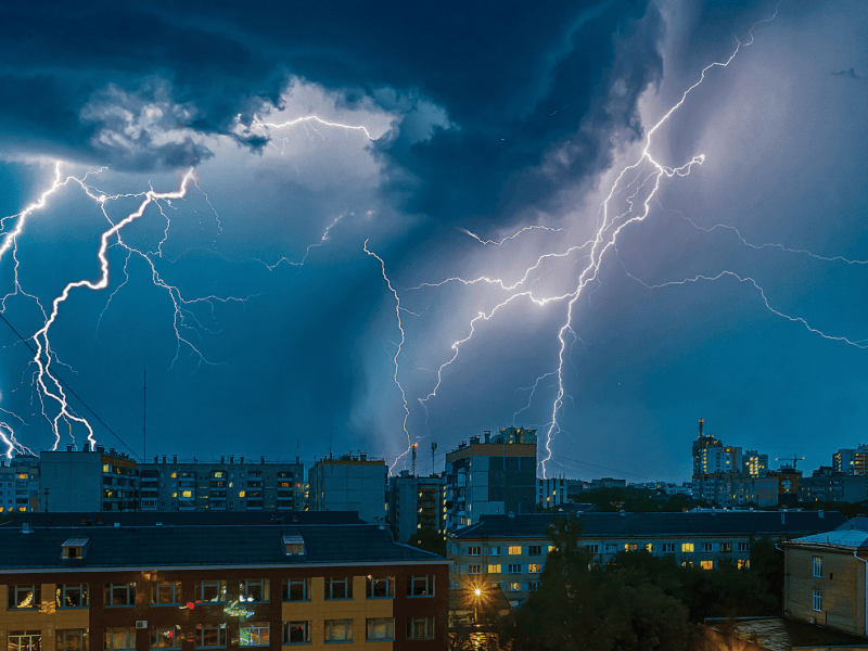 Ein Gewitter mit Blitzen über einer Stadt