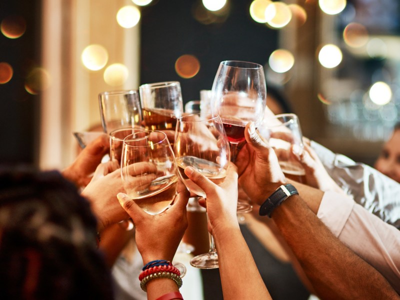 Feierende Menschen stoßen mit Gläsern an