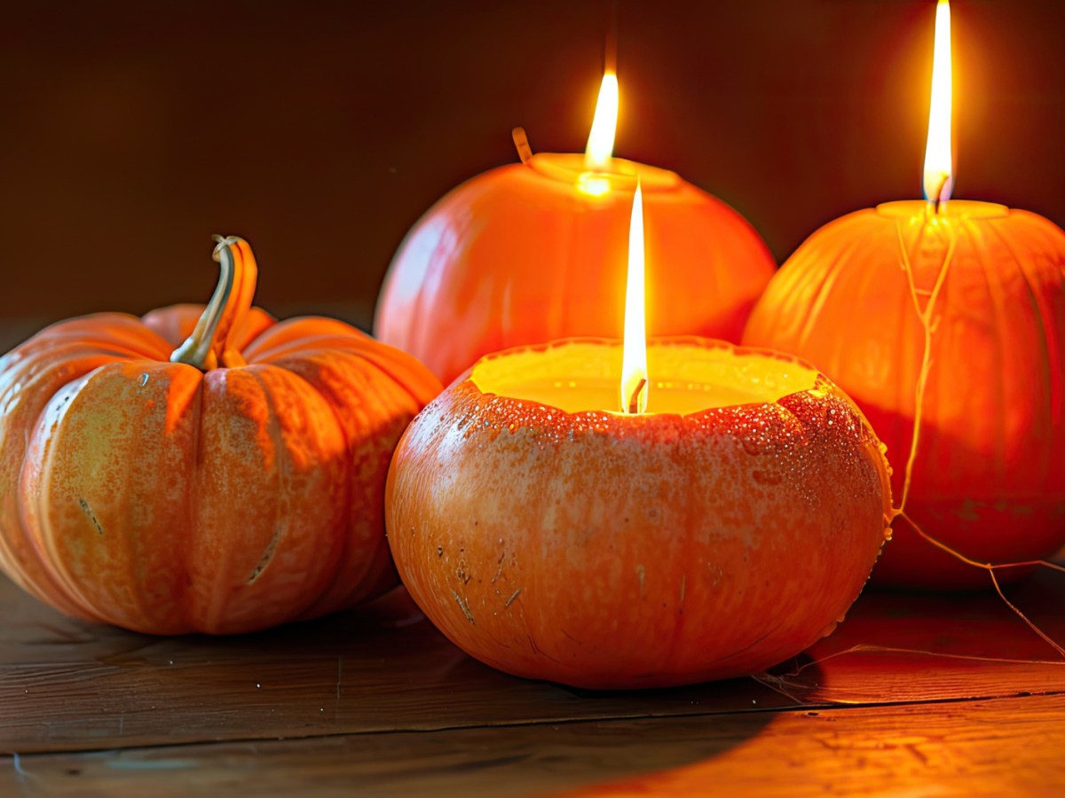 K&uuml;rbis Teelichter auf einem Holztisch.
