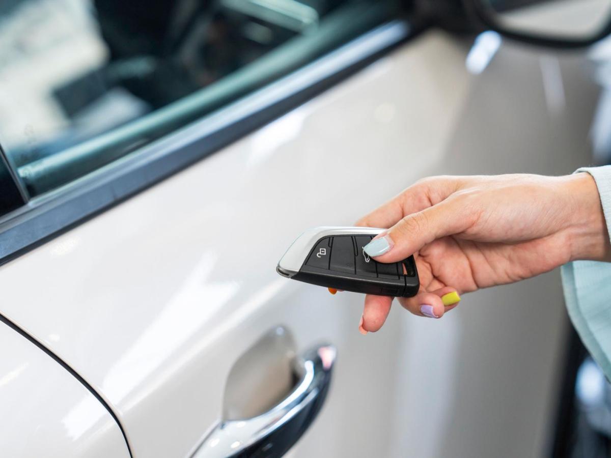 Frau h&auml;lt einen Autoschl&uuml;ssel in der Hand.