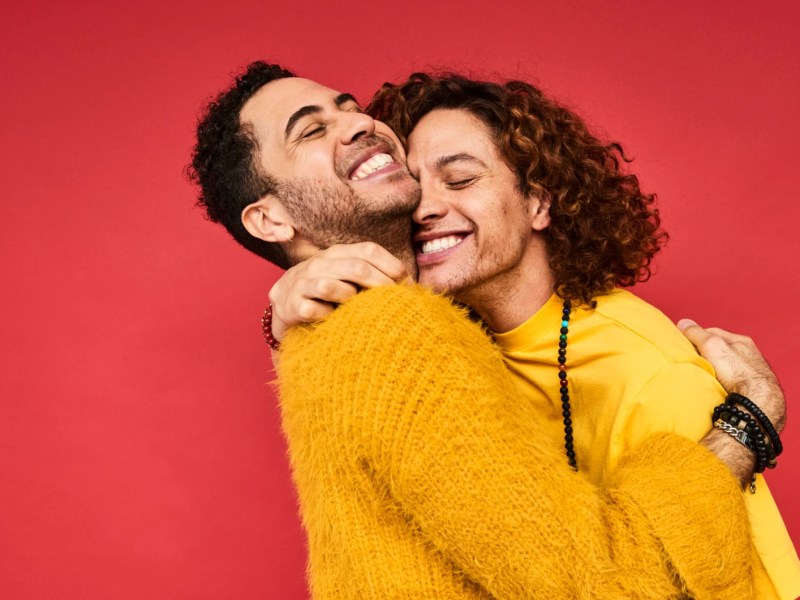 Zwei Männer lachen Arm in Arm
