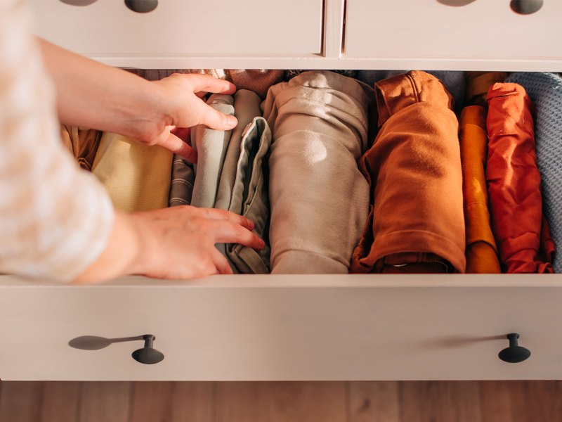 Aufgeräumte Schublade im Kleiderschrank mit sortierten Klamotten.