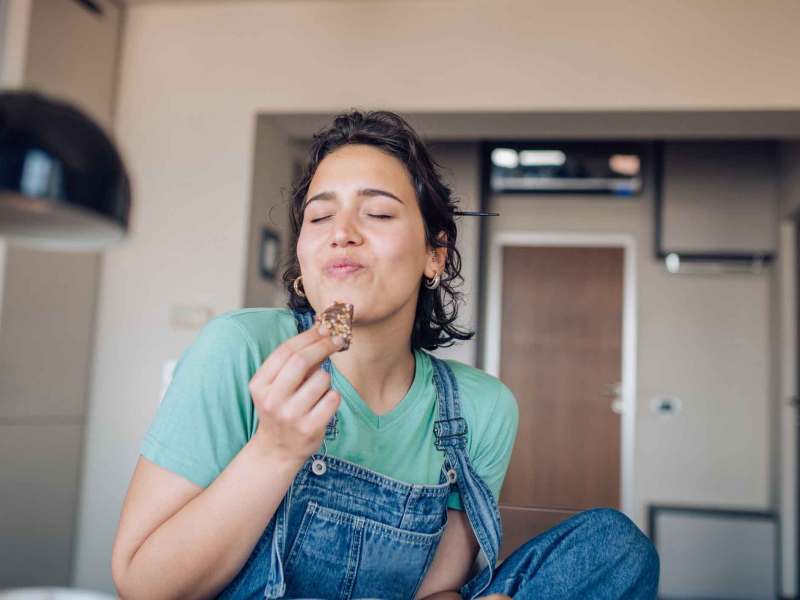 Frau isst genüsslich einen Keks.