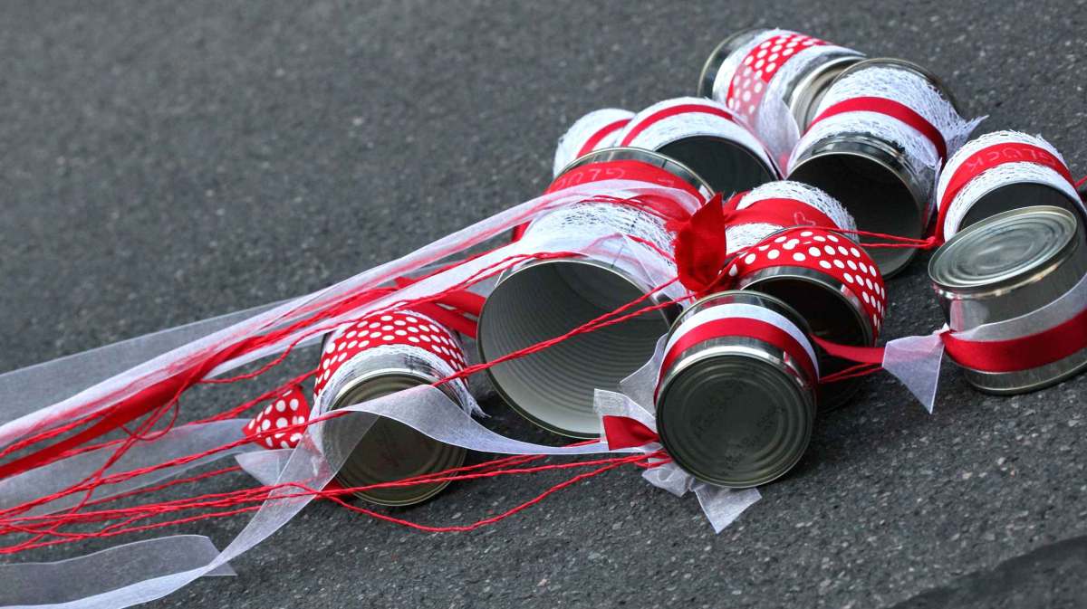 Blechdosen nach einer Hochzeit mit rot-weißen Bändern.