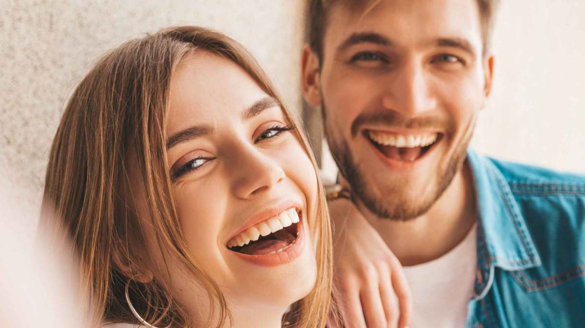 Frau und Mann lachen beherzt.