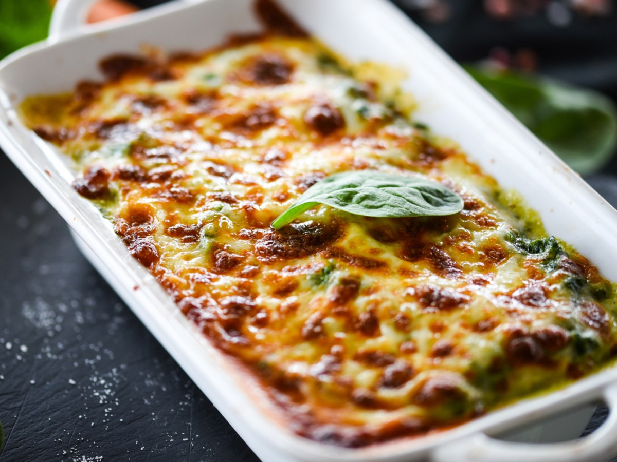 Lasagne mit Spinat in einer wei&szlig;en Auflaufform.