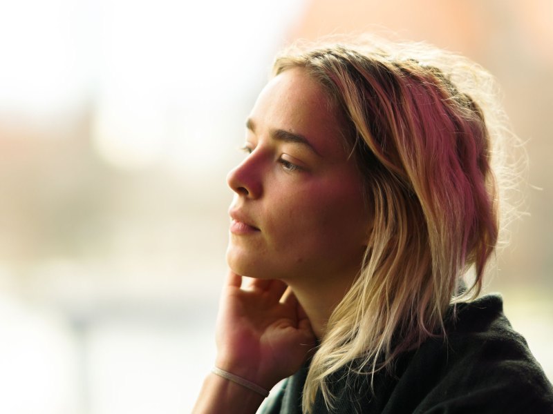 Frau blickt aus dem Fenster