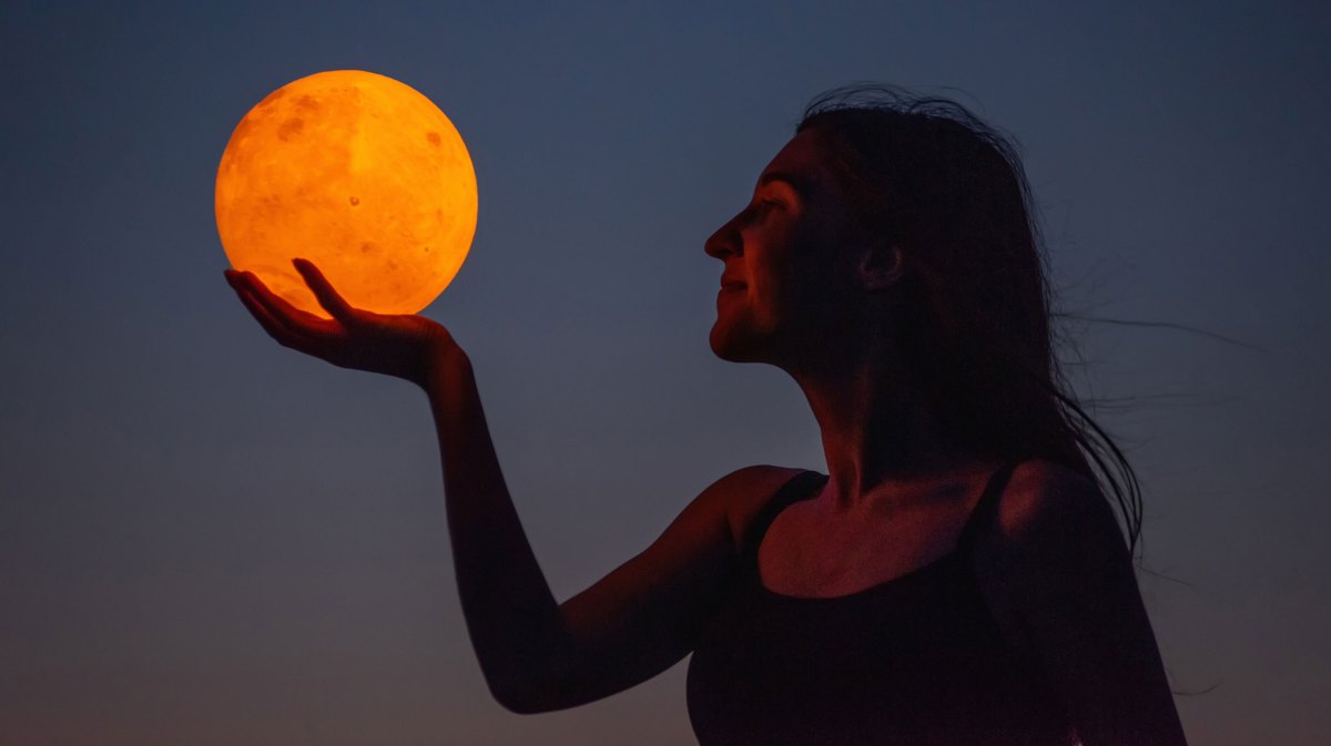 Frau hält Blutmond in der Hand bei Nacht