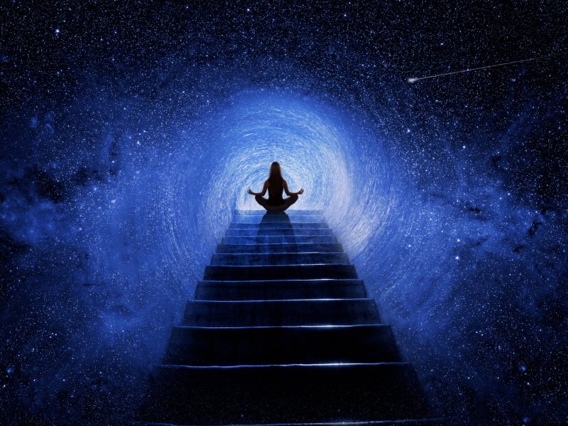 Person sitzt im Schneidersitz auf einer Treppe zum Universum