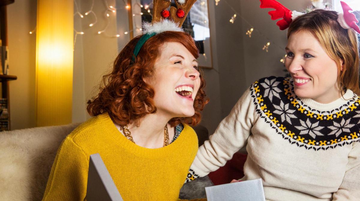 Zwei Frauen schenken sich gegenseitig etwas zu Weihnachten.