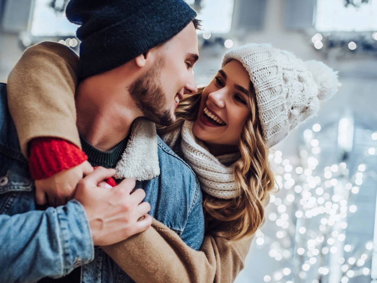 Mann und Frau in Winterbekleidung schauen sich l&auml;chelnd an