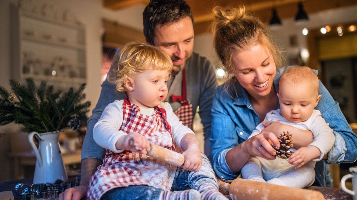 Junge Familie backt in der Weihnachtszeit Plätzchen zu Hause.