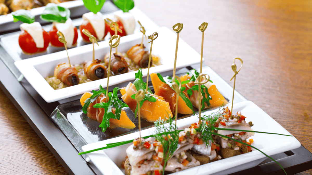 Fingerfood auf weißen Platten angerichtet.