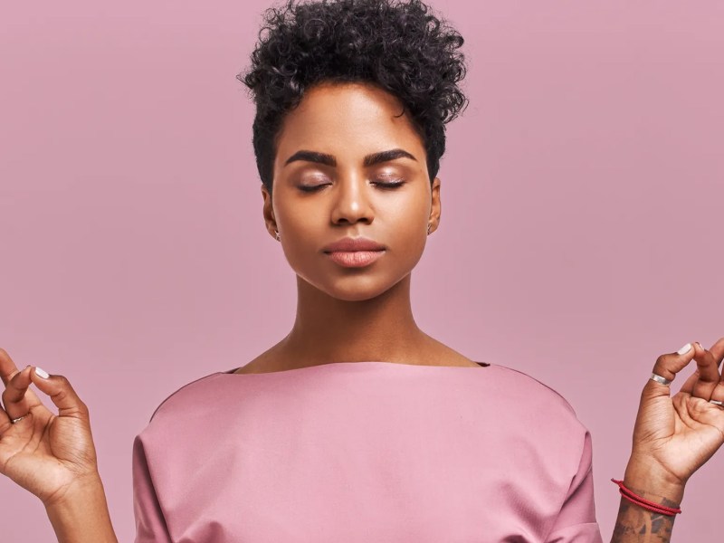 Frau, die meditiert und die Augen geschlossen hält.