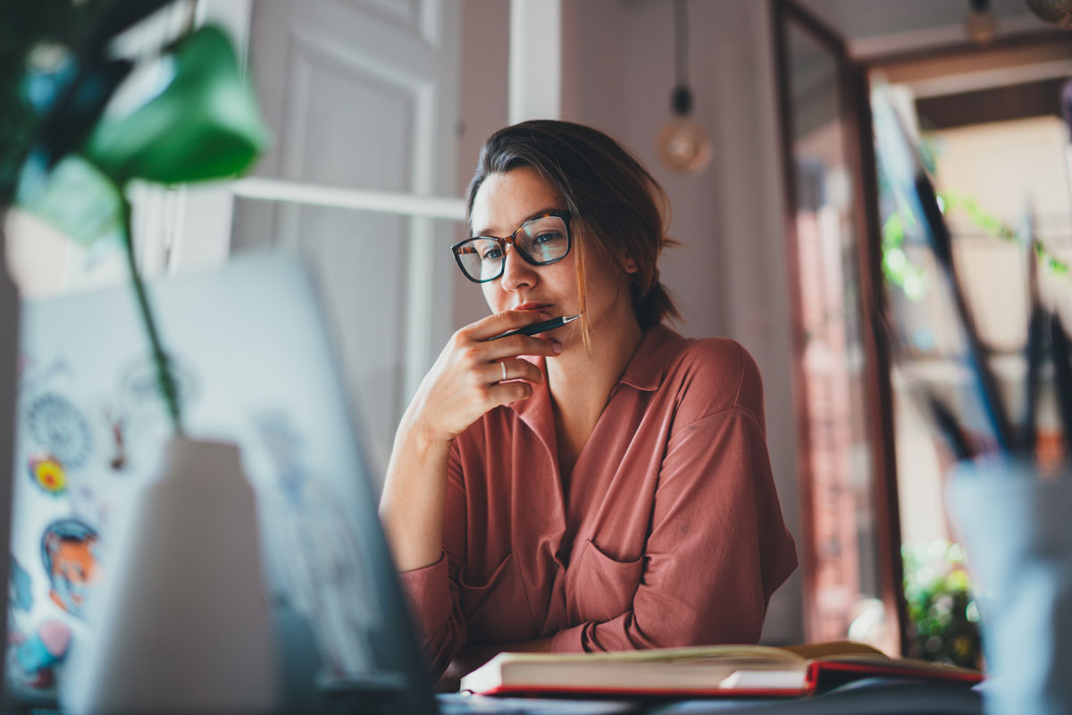 Frau sitzt an ihrem Laptop
