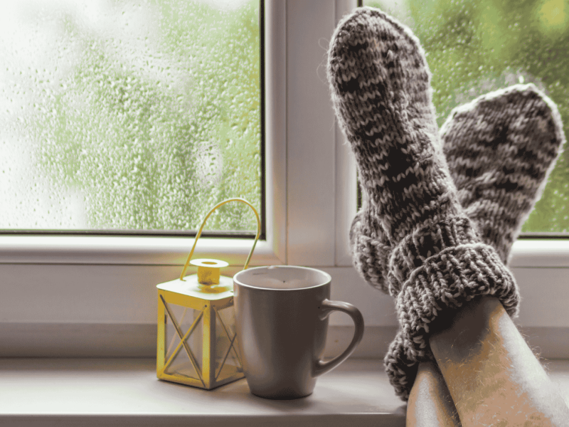 Mann hat Füße auf Fensterbank abgelegt.