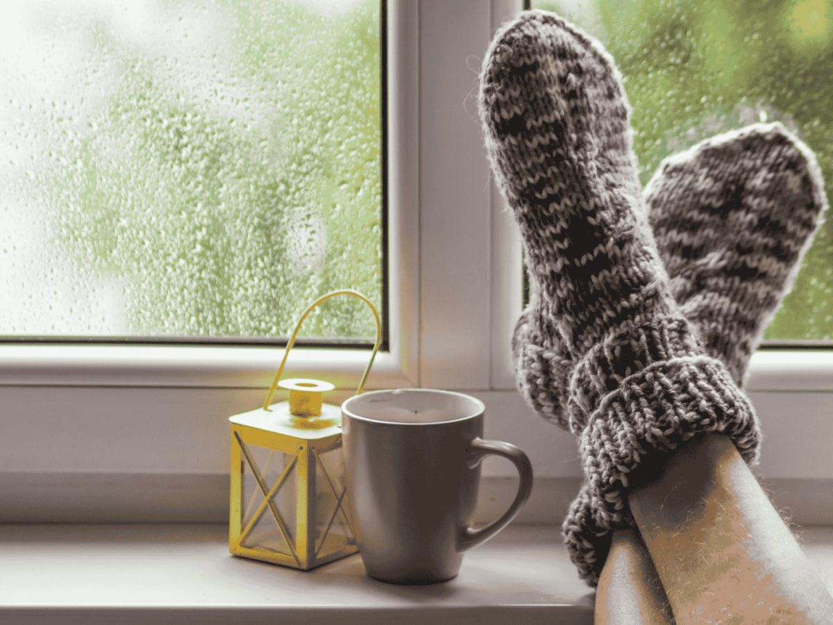 Mann hat Füße auf Fensterbank abgelegt.