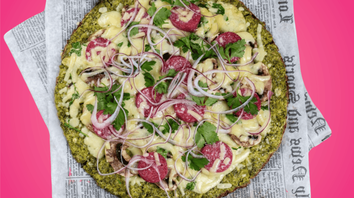 Brokkoli Pizza auf pinkem Untergrund.