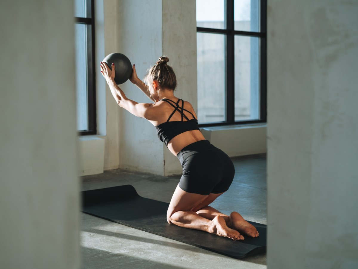 Frau trainiert mit Pilates Ball