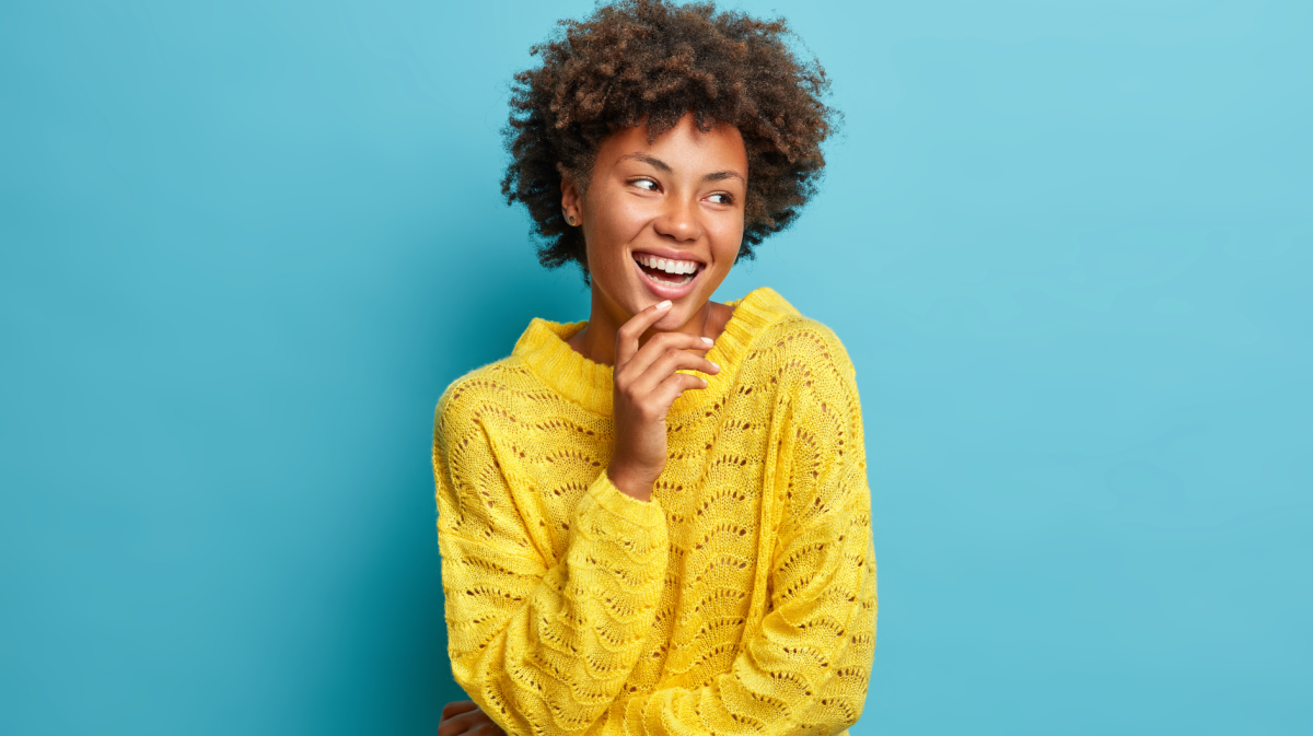 Porträt von netten angenehm aussehende fröhliche Frau lacht glücklich hat breites Lächeln und perfekte weiße Zähne gute Laune sorglos Ausdruck gekleidet lässig posiert gegen blauen Hintergrund.