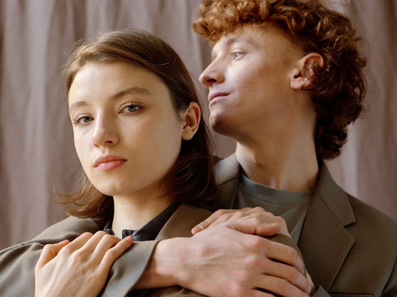 Paar steht Arm in Arm und schaut ernst