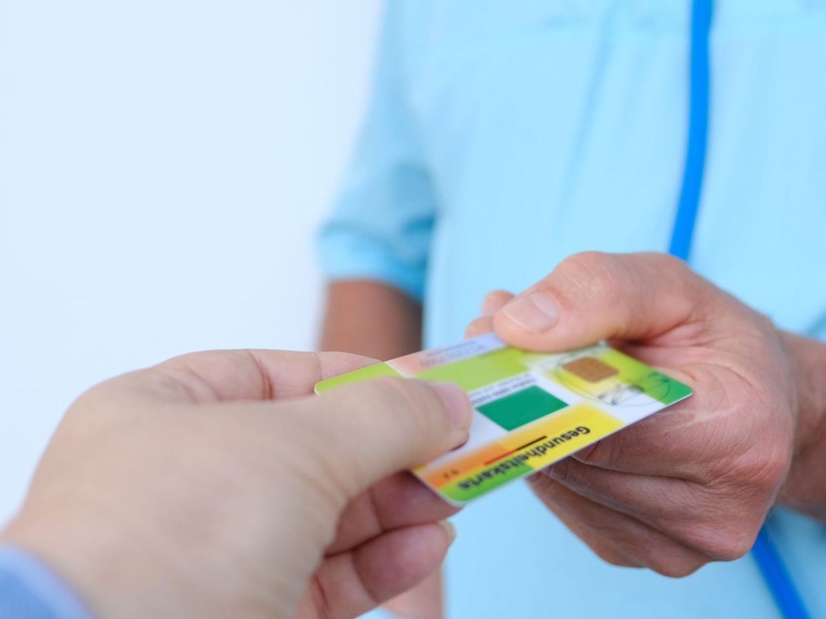 Person &uuml;bergibt eine Krankenkasse
