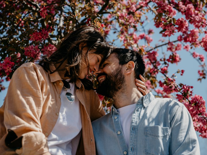 Paar kuschelt unter blühendem Baum
