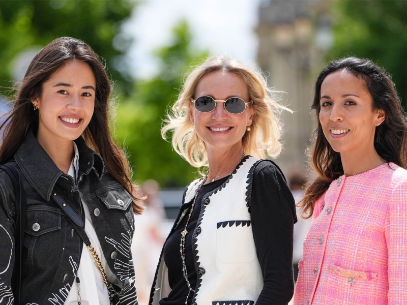 Frauen in schicker Sommerkleidung, die in die Kamera lächeln.