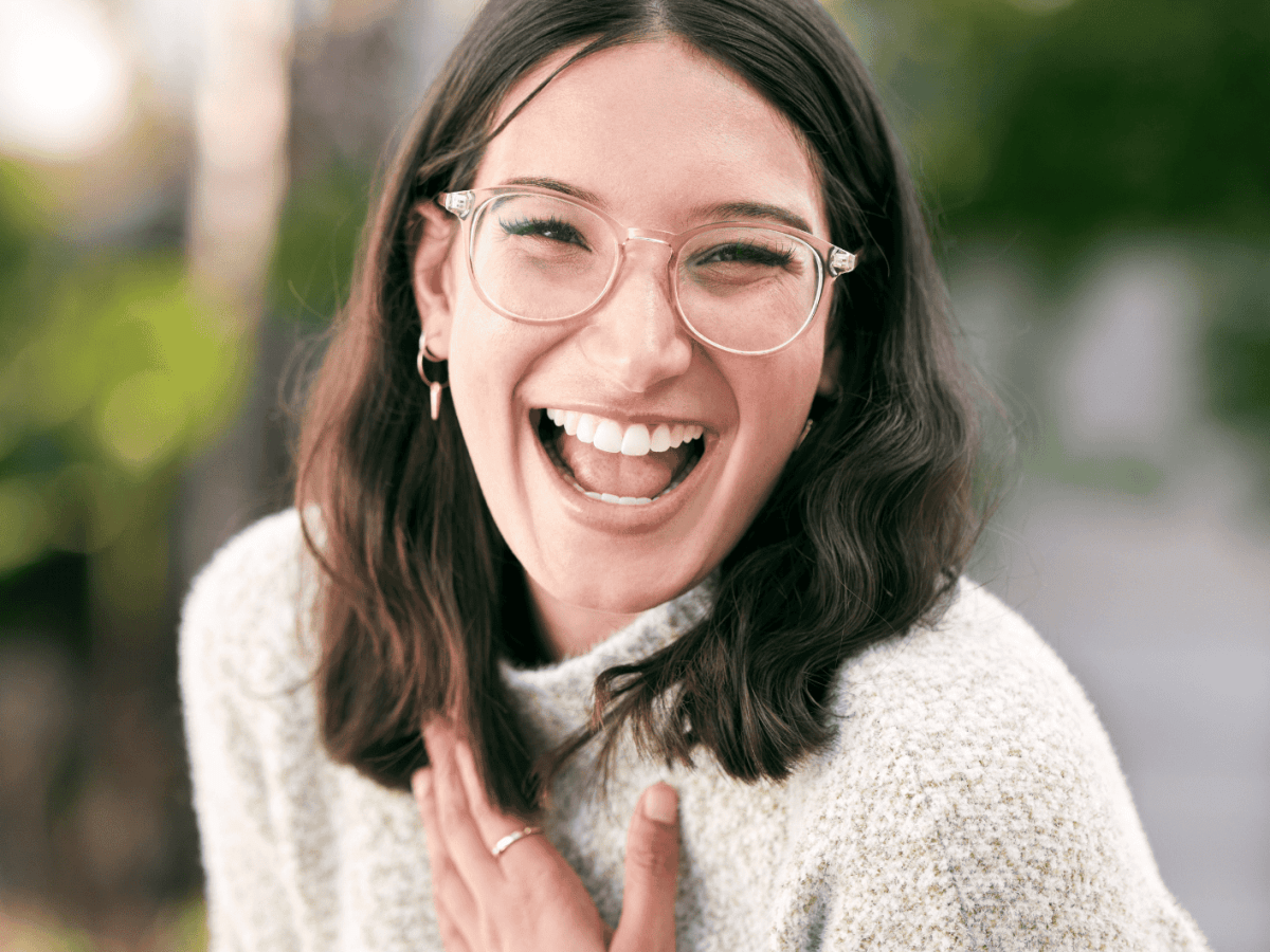 Frau mit Brille l&auml;chelt strahlend in die Kamera