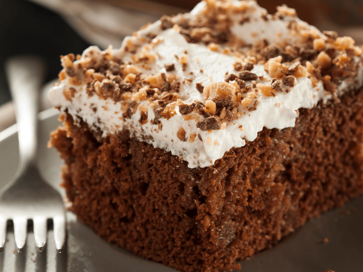 Schokokuchen mit heller Creme auf einem beigen Teller.