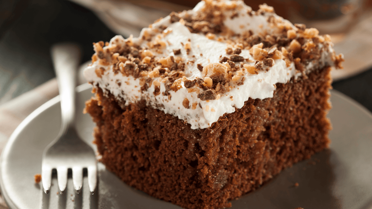 Schokokuchen mit heller Creme auf einem beigen Teller.