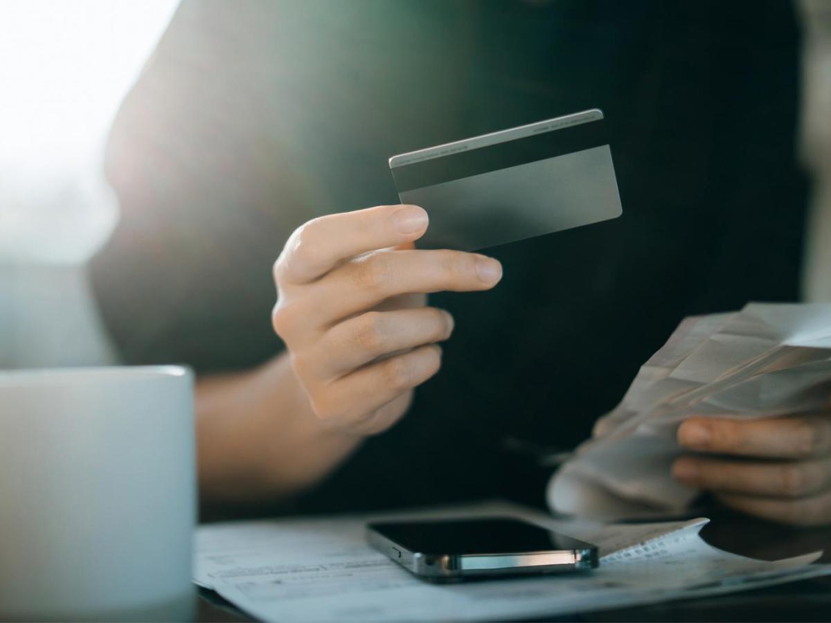 Frau h&auml;lt eine Bankkarte in der Hand.