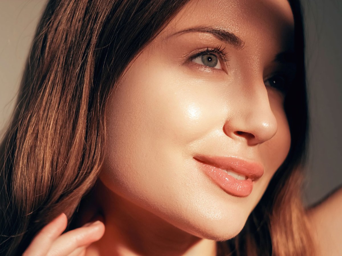 Frau mit einem leichtem Glanz im Gesicht, die von der Sonne angestrahlt wird