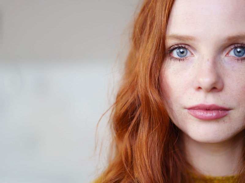 Frau mit roten Haaren schaut in die Kamera