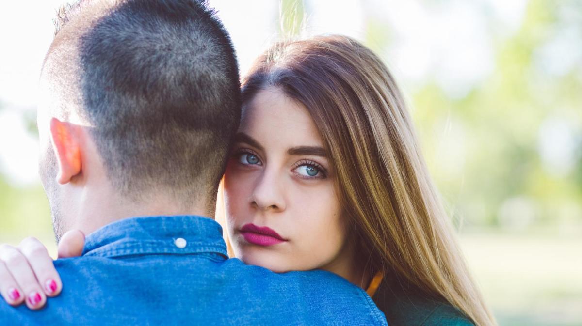 Frau lehnt sich traurig auf der Schulter ihres Partners ab.