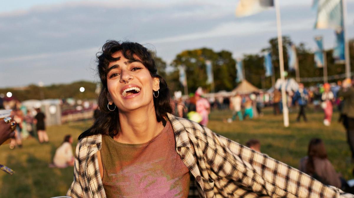 Junge Frau mit schwarzen kurzen Haaren hat Spaß auf einem Festival.