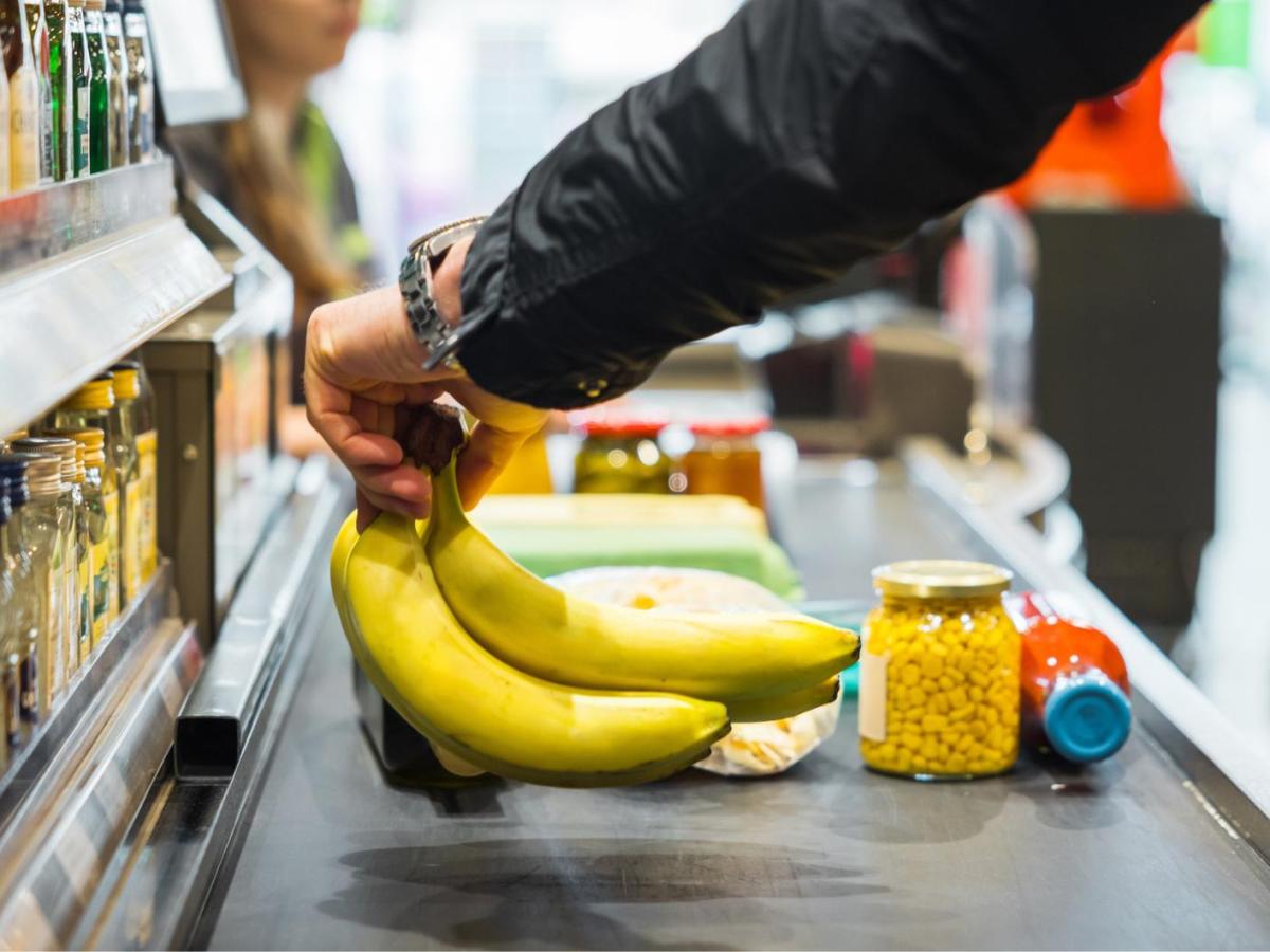 Eine Person legt Bananen auf das Kassenband.