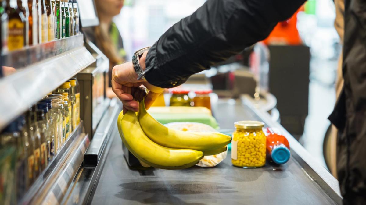 Eine Person legt Bananen auf das Kassenband.